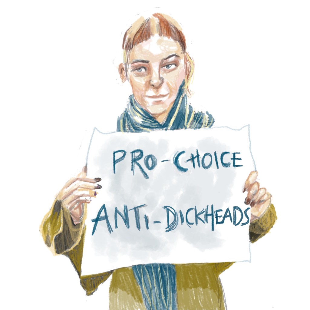 Woman holding a sign saying 'pro-choice anti dickheads'. Image by Myfanwy Tristram.